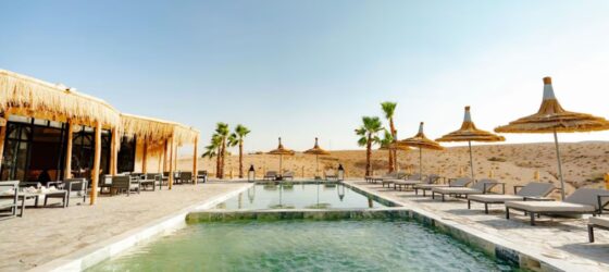 Agafay Desert camp with swimming pool and shaded lounge area near Marrakech