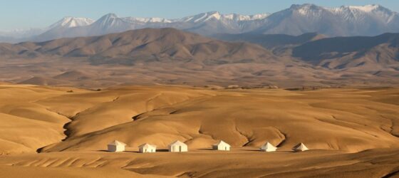 Luxury glamping tents in Agafay Desert with Atlas Mountains in the background