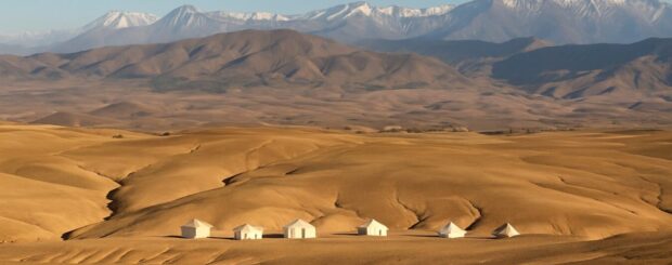 Luxury glamping tents in Agafay Desert with Atlas Mountains in the background