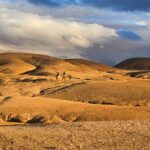 Agafay Desert day trip: Traveler riding a camel through the Agafay Desert near Marrakech, Morocco.
